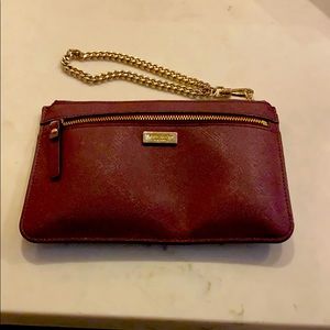 Wine colored Kate Spade wristlet with gold chain